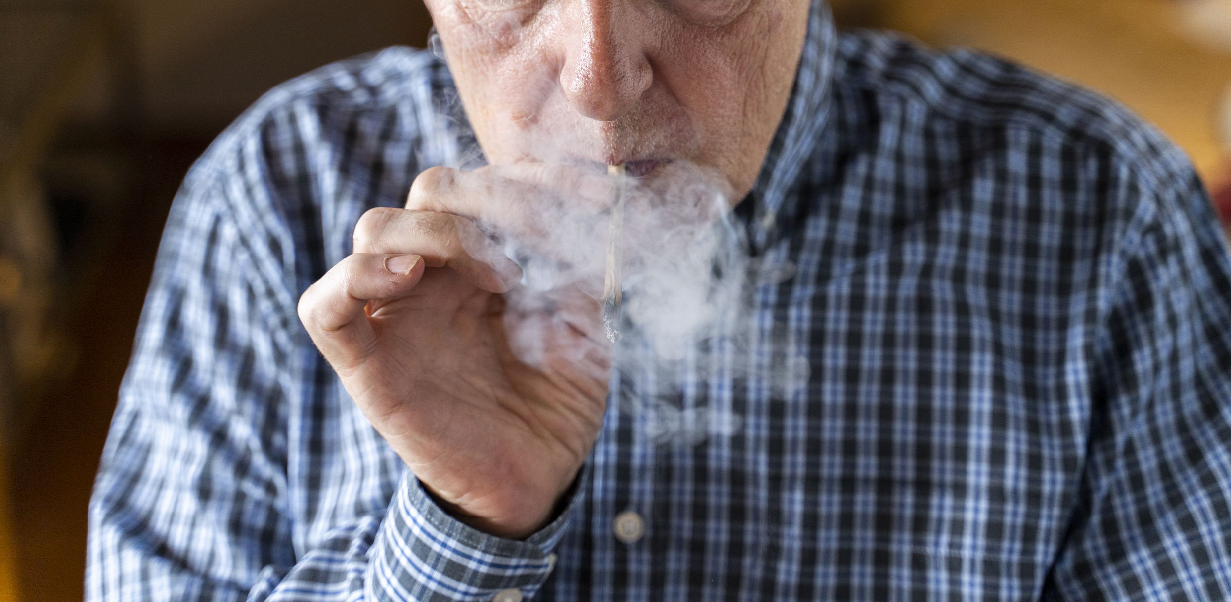Senior man at home smoking marihuana joint