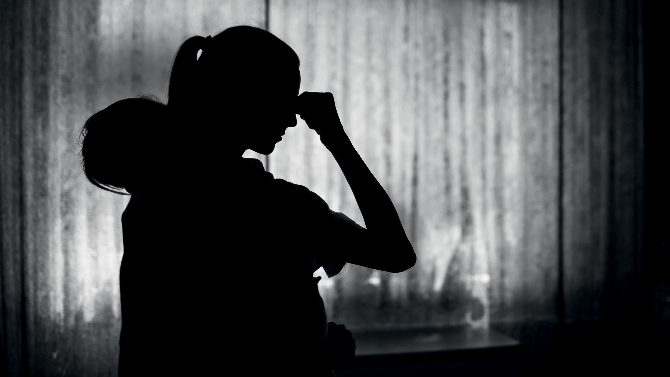 Exausted tired mother at home taking care of baby