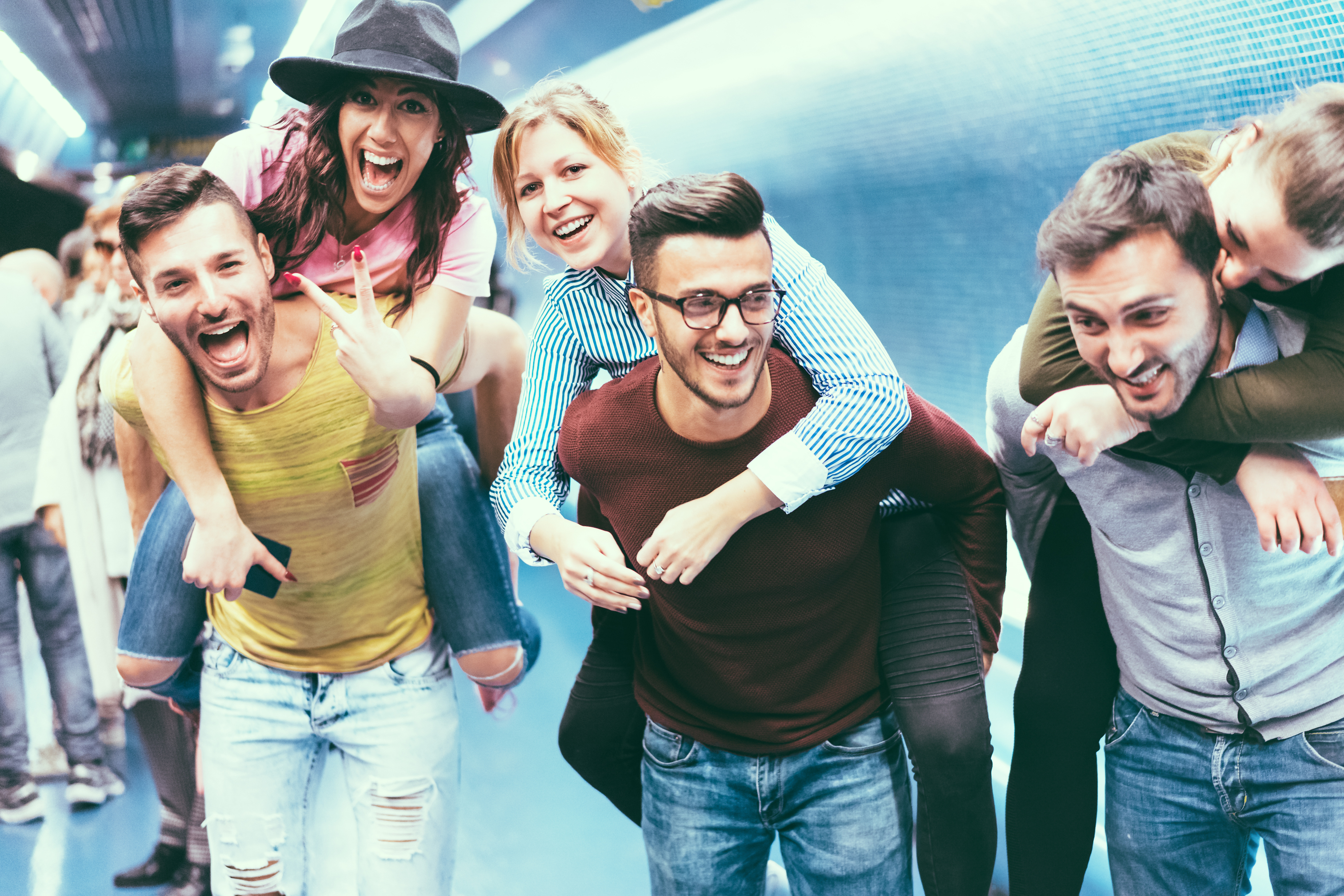 Group of friends having fun in underground metropolitan station – Young people hanging out ready for party night – Friendship and youth lifestyle concept – Focus on center girl face