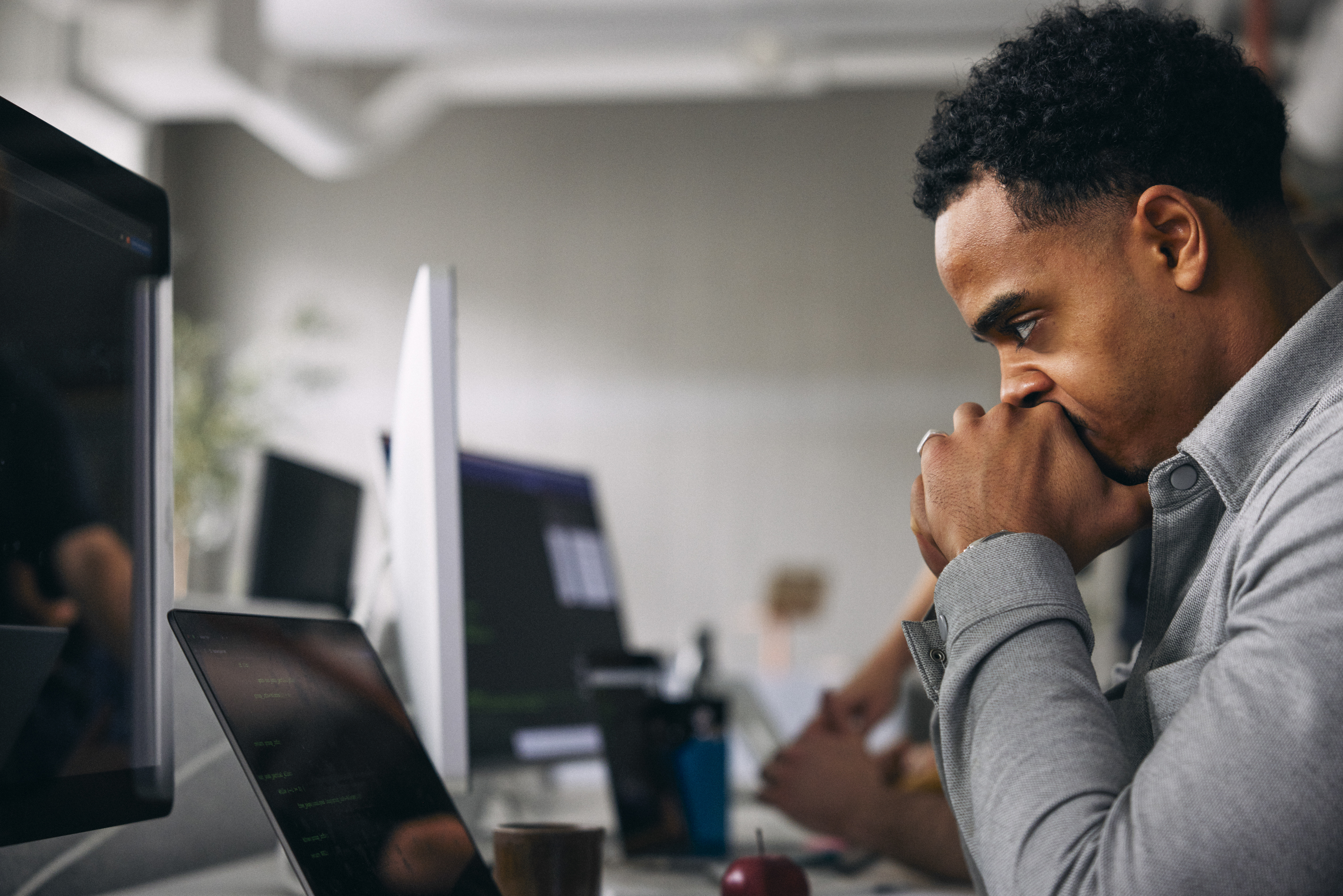 Exhausted male computer programmer at tech startup office